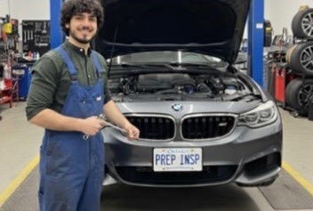 Mechanic in front of an inspected BMW in a shop