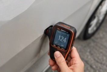Paint thickness gauge reading on a door panel
